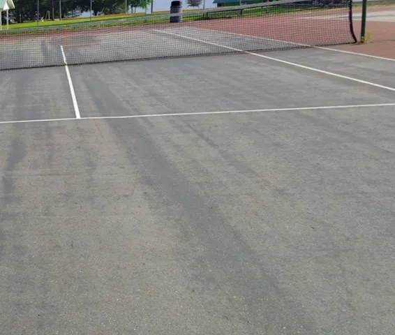 Tarmac tennis court with white court markings and net